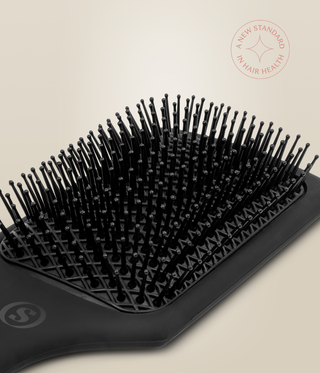 Angled close-up of the MicroCell Cushion Brush's ball-tipped bristles and lattice-patterned cushion.